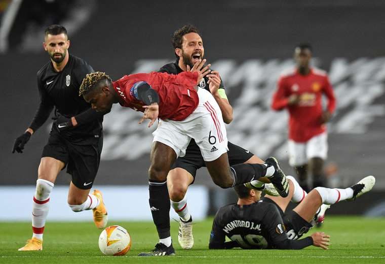 Paúl Pogba, del Manchester United, es trabado por un jugador del Granada. Foto: AFP