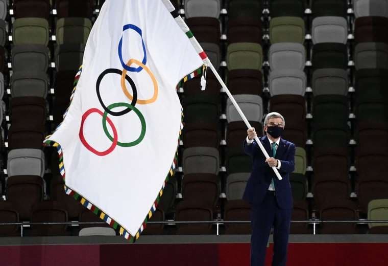 El presidente del COI Thomas Bach ondea la bandera olímpica. Foto: AFP